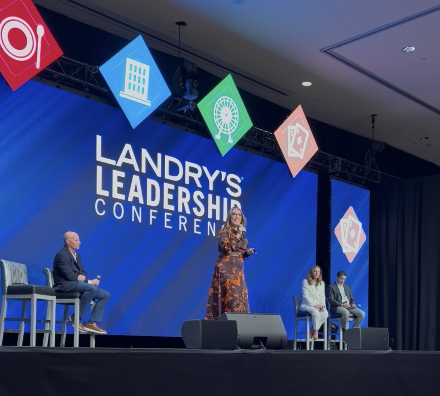 Loretta Markevics speaking on stage at Landry's Leadership Conference