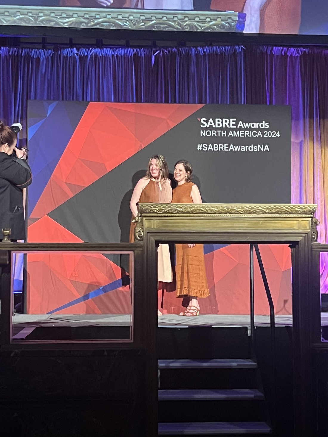 Loretta Markevics accepting a SABRE Award on stage in 2024